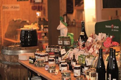 Tisch im Hofladen mit vielen Produkten in Gläsern und Flaschen
