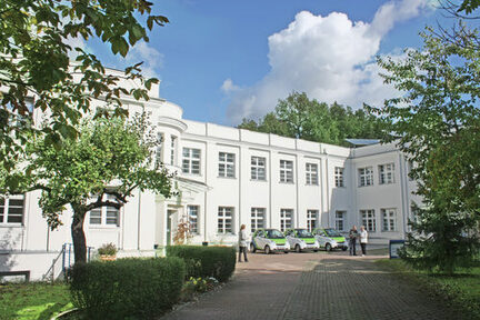 AUßenansicht des Unternehmenssitzes der WOBEGE in der Winckelmannstraße, zweistockiges weißes Gebäude mit Hof